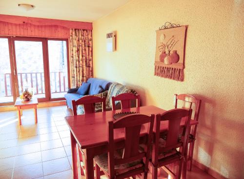 a living room with a table and chairs and a couch at Kione Calgary in Pas de la Casa
