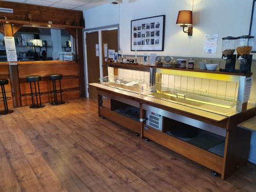 a restaurant with a counter and a bar with stools at Brukshotellet Skinnsberg in Skinnskatteberg