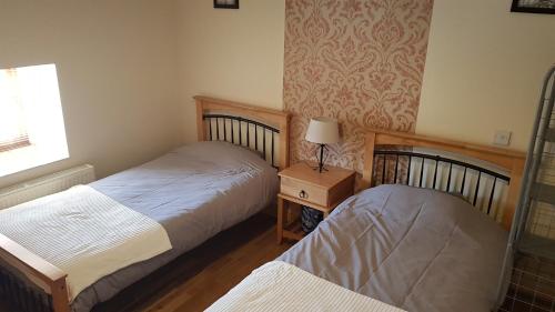 a bedroom with two beds and a lamp on a table at Apartment 3 bedroom banagher town centre in Banagher