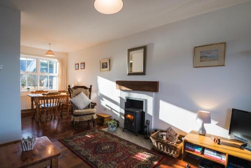 ein Wohnzimmer mit Kamin und Tisch in der Unterkunft Dunfanaghy - Sea Views- in village - parking in Dunfanaghy