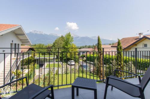 einen Balkon mit Stühlen und Blick auf den Hof in der Unterkunft Appartement Duplex Jardin in Sévrier