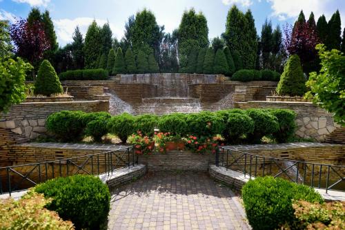 a garden with bushes and flowers on a stone wall at Zoloto Karpat in Stryi