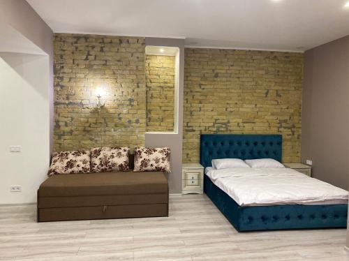 a bedroom with a blue bed and a brick wall at Heart Kyiv Apart-Hotel in Kyiv