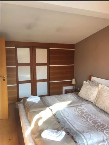 a bedroom with a large bed with a wooden wall at Luxury houses in Dobrinishte in Dobrinishte