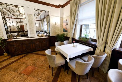 a dining room with a table and chairs and a mirror at Zoloto Karpat in Stryi