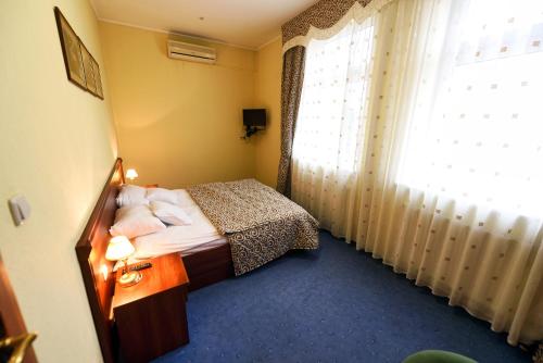 a hotel room with a bed and a window at Zoloto Karpat in Stryi