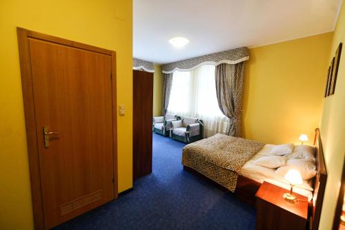 a hotel room with a bedroom with a bed and a chair at Zoloto Karpat in Stryi