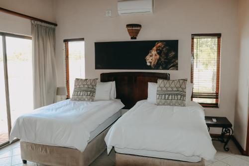 a bedroom with two beds and a tv on the wall at 119 Zebula in Mabula
