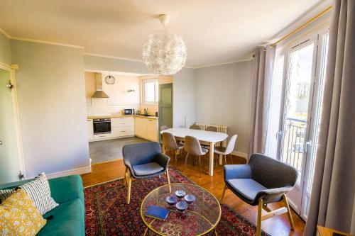 un salon avec une table et des chaises et une cuisine dans l'établissement Appartement Rousseau - Centre Ville 5 minutes GARE, à Tours