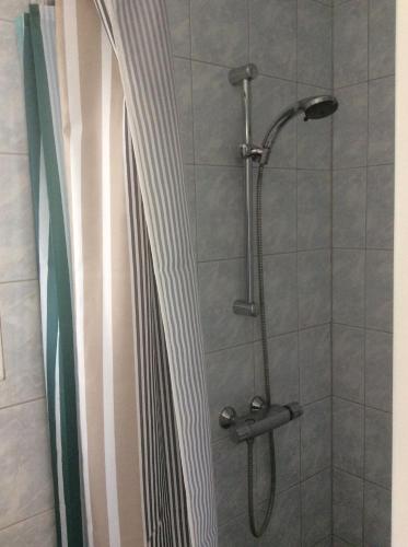 eine Dusche mit Duschvorhang im Bad in der Unterkunft Vakantiehuisje vlakbij de duinen in Oostvoorne