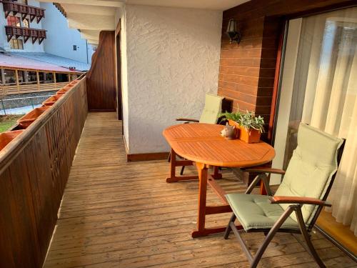 a wooden table and chairs on a balcony at Francesco's Mountain Apartment in Predeal