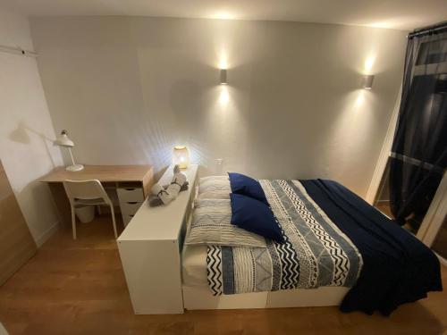 - une chambre avec un lit, un bureau et une table avec un bureau dans l'établissement T2 lumineux centre ville proche métro, parking gratuit,1 chambre, 1 grande pièce à vivre, à Toulouse