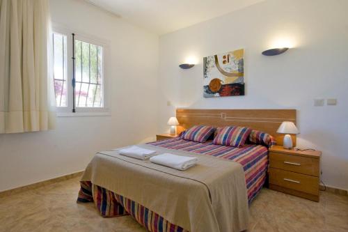 a bedroom with a bed with two towels on it at Villa Paolo in Calpe