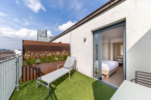 a balcony with a bed and a bedroom on a building at Hotel Zeitgeist Vienna Hauptbahnhof in Vienna