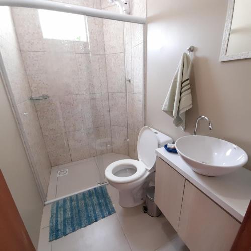 a bathroom with a shower and a toilet and a sink at Moradas Cantinho da Guarda in Guarda do Embaú