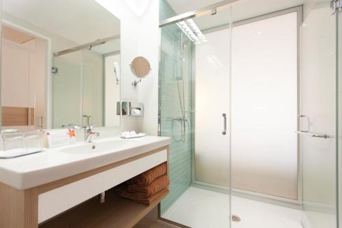 ein Bad mit einem Waschbecken und einer Dusche in der Unterkunft Hotel Riu San Francisco - Adults Only in Playa de Palma