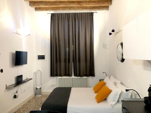 um quarto com uma cama com almofadas laranja e uma janela em Residenza Pedrotti em Vicenza