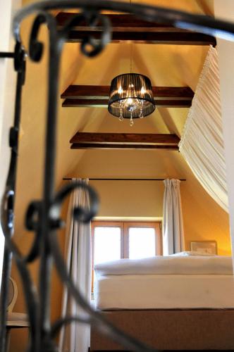 a chandelier in a room with a bed and a window at Hotel Herrnschloesschen in Rothenburg ob der Tauber