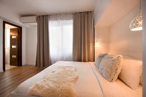 a bedroom with a large white bed with a window at WHITE HAVEN - Calea Victoriei Studio in Bucharest