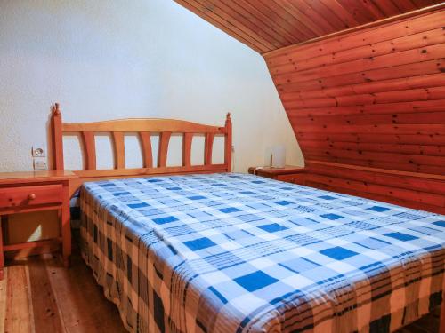 - une chambre avec un lit et un mur en bois dans l'établissement Kione Lake Placid, au Pas de la Case