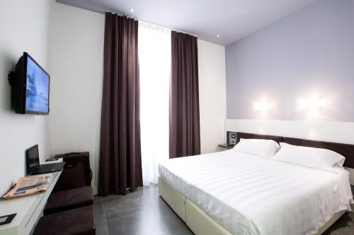 ein Hotelzimmer mit einem Bett und einem TV in der Unterkunft Crosti Hotel in Rom