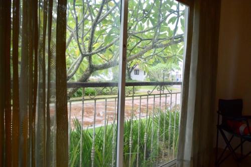 a window with a view of a tree at 3BR Apt @CadaquesCaribe Bayahibe in San Rafael del Yuma