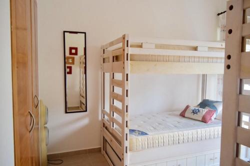 a bedroom with two bunk beds and a mirror at 3BR Apt @CadaquesCaribe Bayahibe in San Rafael del Yuma