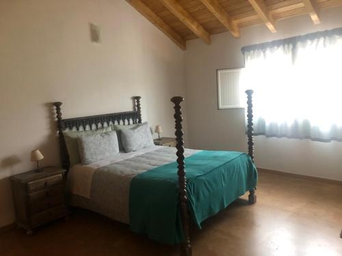 a bedroom with a bed and a window at Casas da Moagem in São Domingos