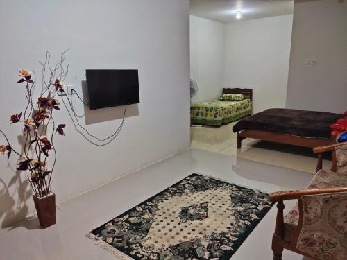 a living room with a tv on a white wall at Bukittinggi Homestay 2 in Bukittinggi
