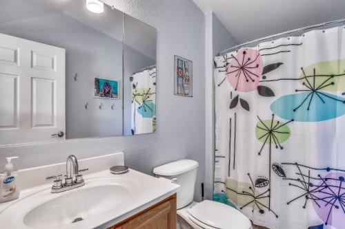 a bathroom with a sink and a toilet and a shower curtain at Cayo Loco in Little Torch Key