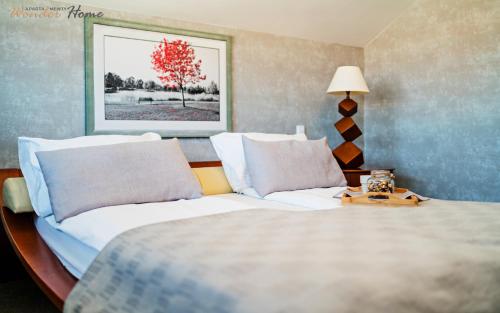 a bedroom with a bed and a table with a lamp at Wonder Home - Apartament Cud Malina z kominkiem, klimatyzacją i widokiem na Karkonosze in Karpacz