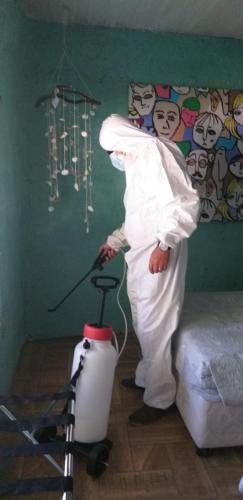 a man standing in a room with a vacuum at Cabañas El Desván in Puente Negro
