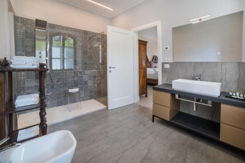 a bathroom with a sink and a mirror and a tub at Casa Guarnieri in Feltre