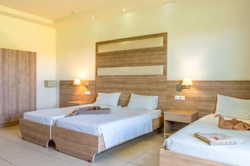 a hotel room with two beds and a mirror at Stamos All Inclusive in Faliraki
