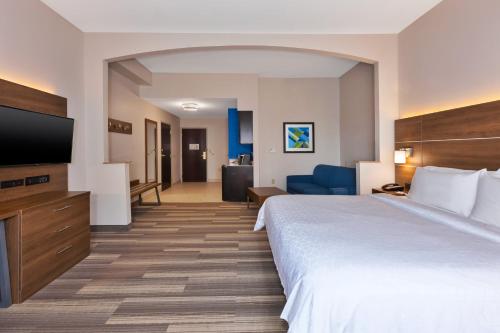 a hotel room with a large bed and a flat screen tv at Holiday Inn Express Hotel & Suites Warminster-Horsham by IHG in Warminster