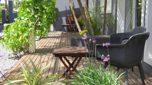 a patio with two chairs and a table and some plants at Bloemenzee Boutique B&B in Gordonʼs Bay