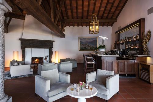 a living room with a fireplace and a bar at Villa Orselina - Small Luxury Hotel in Locarno