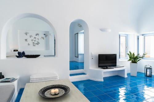a living room with blue floors and a tv at Astra Suites in Imerovigli