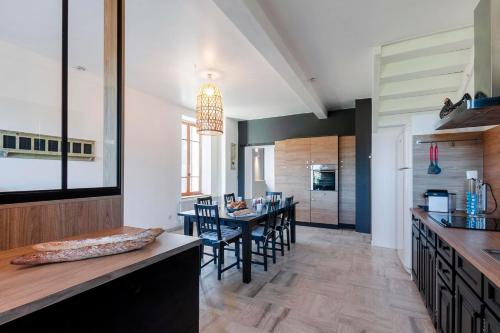 une cuisine et une salle à manger avec une table et des chaises dans l'établissement Gîte de la Prévôté, à Sergy