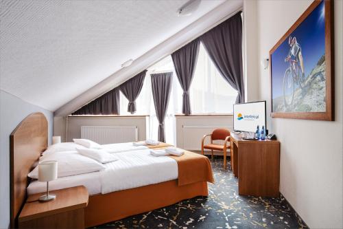 pokój hotelowy z dużym łóżkiem i biurkiem w obiekcie Interferie Aquapark Sport Hotel Malachit w Świeradowie Zdroju
