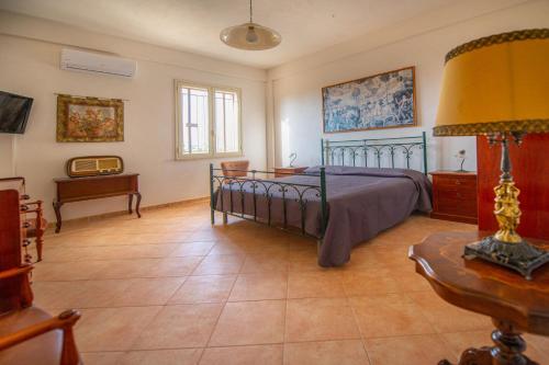マツァーラ・デル・ヴァッロにあるVilla Matilde - Xenia Sicily Villasのベッドルーム(ベッド1台、テーブル、ランプ付)