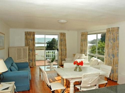 a living room with a table and a blue couch at Lagoona Inn in Knysna