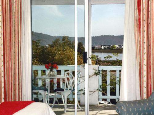 a balcony with a table and a view of the water at Lagoona Inn in Knysna