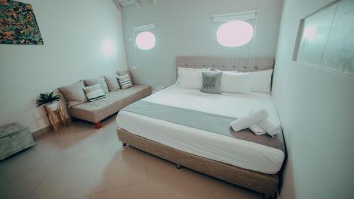 a bedroom with a large bed and a couch at Casa Amanzi Cartagena by Bernalo Hotels in Cartagena de Indias