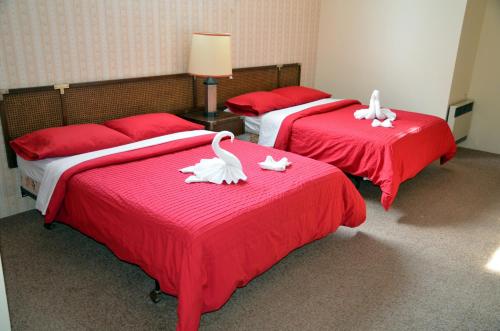 Dos camas con cisnes blancos en una habitación en Tornado's Motel, en Port Loring