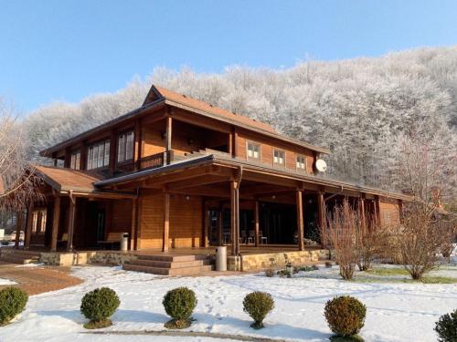 ein großes Holzhaus mit Schnee auf dem Boden in der Unterkunft Belle Royalle in Lisarnya