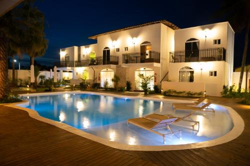 a swimming pool in front of a house at night at Mero Hotel Boutique in Barra Grande