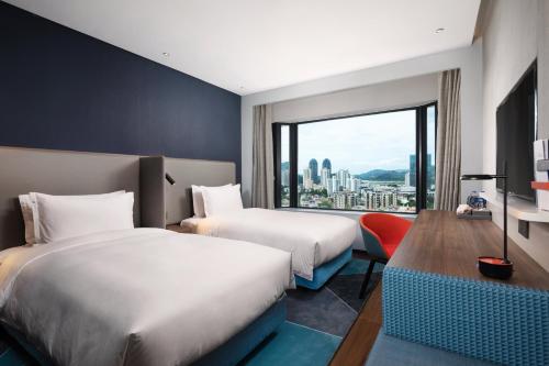 a hotel room with two beds and a large window at Holiday Inn Express Shenzhen Dongmen by IHG in Shenzhen
