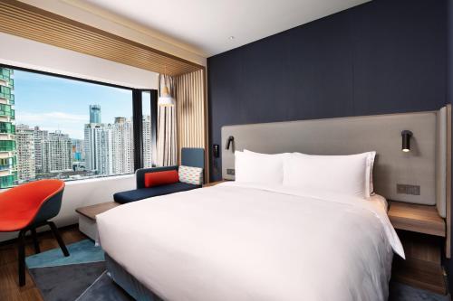 a hotel room with a large bed and a large window at Holiday Inn Express Shenzhen Dongmen by IHG in Shenzhen