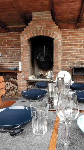 a table with glasses and plates and a brick oven at Bed & Badacsony in Badacsonytördemic